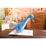 Peluche de dinosaurio azul en un salón sobre una mesa