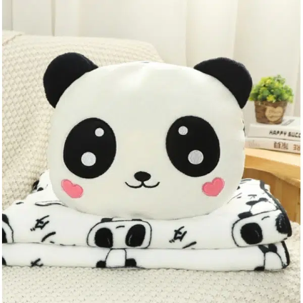 Adorable peluche panda con manta en un sofá