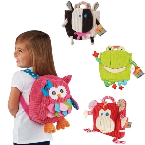 Una niña con una mochila de peluche de un búho rosa y otras tres mochilas de peluche con una vaca, una rana y un mono rojo