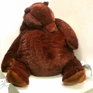 Un enorme oso de peluche de aspecto suave sentado en una habitación luminosa