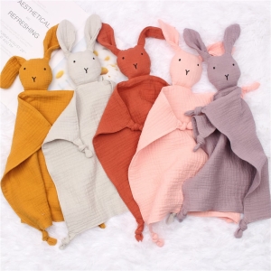 Cinco peluches de conejo de diferentes colores reunidos en una tela de color claro