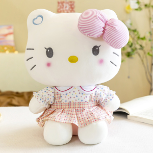 Simpático peluche de Hello Kitty sentado frente a un libro