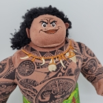 peluche del personaje Moana Maui de los dibujos animados de disney vemos su cabeza y su busto totalmente tatuados