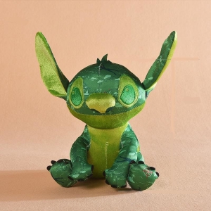 Stitch, el héroe de los dibujos animados de Disney, es un peluche verde oscuro, con las orejas y la barriga verde claro, sentado con las orejas hacia arriba