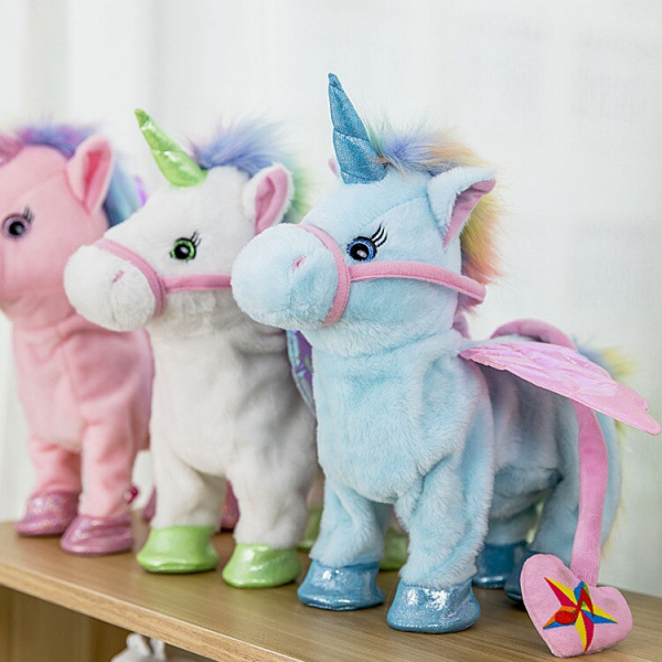 3 unicornios de felpa colocados uno al lado del otro en una estantería, uno rosa, uno verde, uno azul, cada uno con pequeñas alas rosas